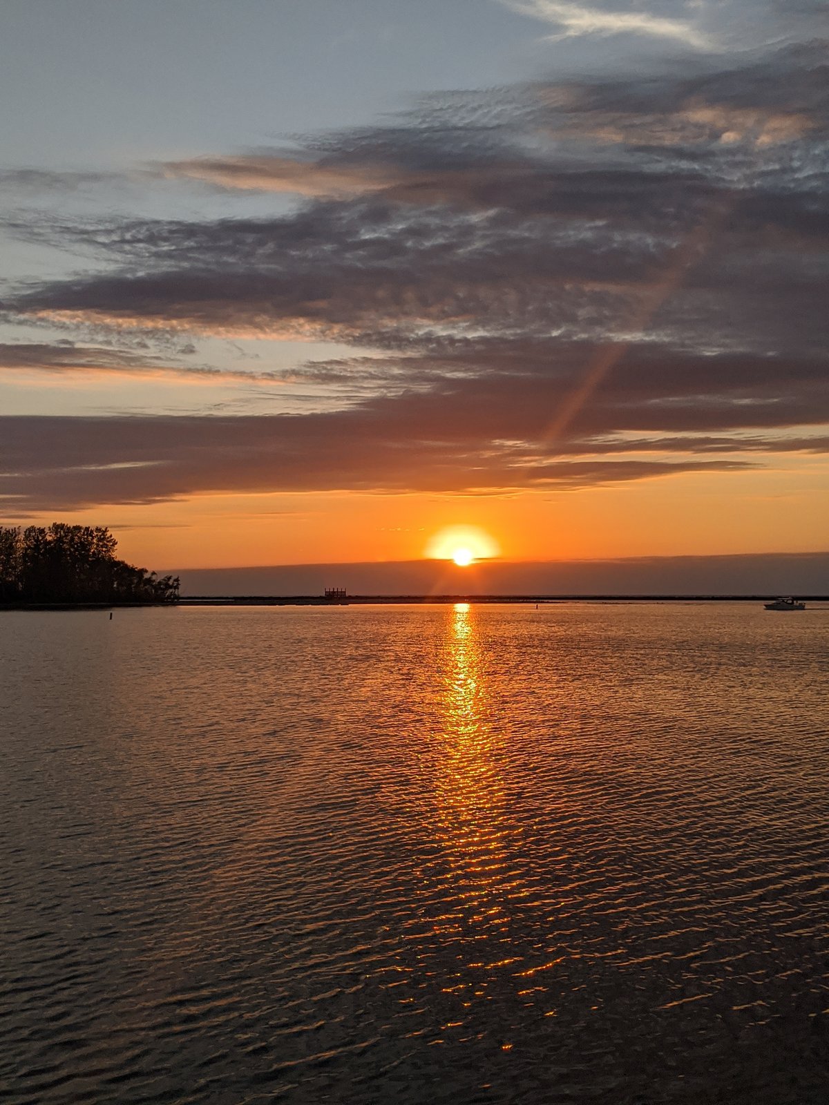 Sunset over Lake Erie at Pearl Beach Cottages, with the sun reflected in a long golden trail on the water